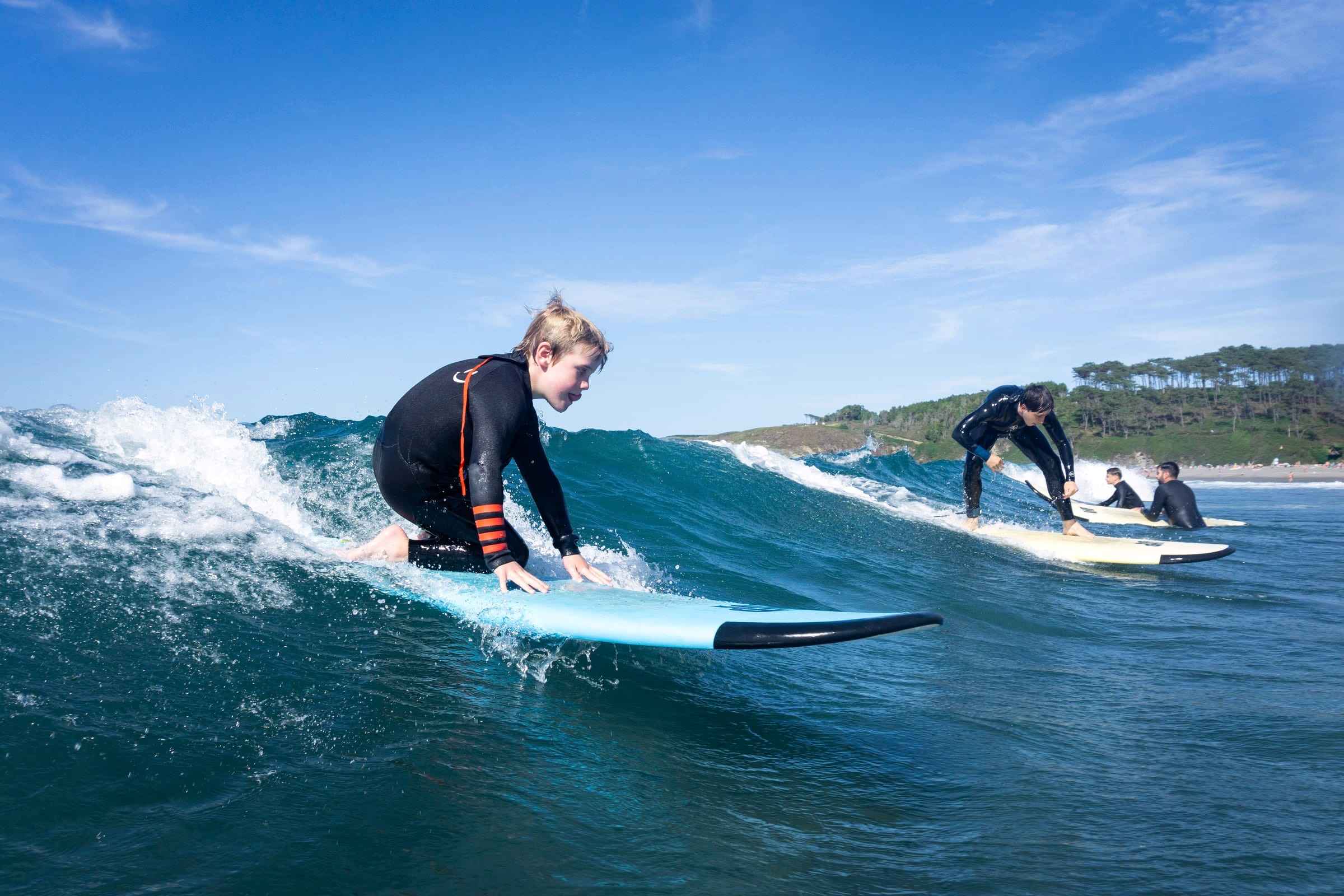 Niño surfeando su primera ola en la playa de Frexulfe, Asturias