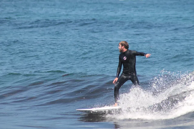 Clase de surf privada con un monitor en la playa de Frexulfe