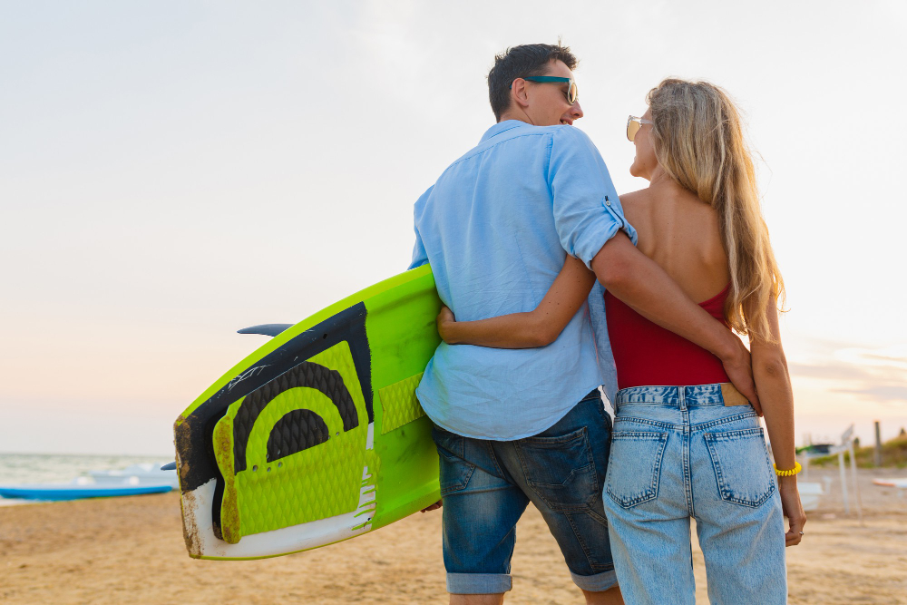 young-couple-view-from-back-having-fun-beach-walking-with-surfboard